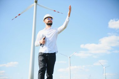 Alternatif yenilenebilir rüzgar enerjisi çiftliğinde çalışan mühendis - sürdürülebilir enerji endüstrisi kavramı.