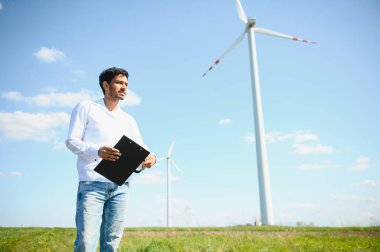 Hintli mühendis buğday tarlasında türbin üretimini kontrol ediyor..