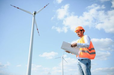 Sürdürülebilir enerji endüstrisindeki işçiler - Alternatif yenilenebilir rüzgar enerji istasyonunda çalışan mühendis.