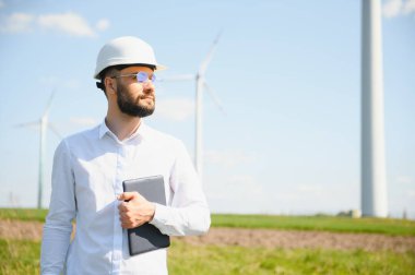 Alternatif yenilenebilir rüzgar enerjisi çiftliğinde çalışan mühendis - sürdürülebilir enerji endüstrisi kavramı.