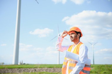 Hintli mühendis buğday tarlasında türbin üretimini kontrol ediyor..