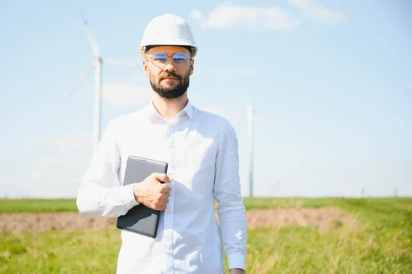 stock image Engineer in field checking on turbine production.