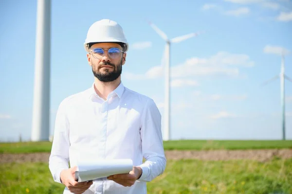 stock image Engineer in field checking on turbine production.