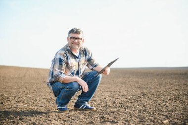 Bir çiftçi ekmeden önce toprağın kalitesini kontrol eder