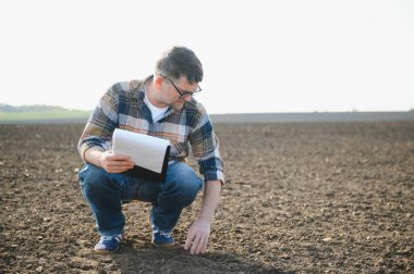 Bir çiftçi ekmeden önce toprağın kalitesini kontrol eder