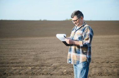 Tarlada yaşlı bir çiftçi. Tarım, mahsul kavramı