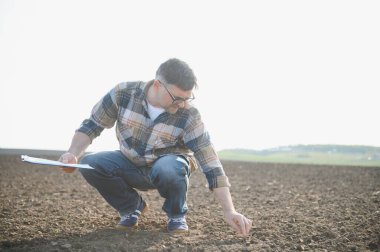 Bir çiftçi ekmeden önce toprağın kalitesini kontrol eder