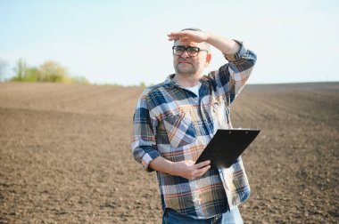 Bir çiftçi ekmeden önce toprağın kalitesini kontrol eder