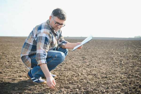 Tarlada gözlüklü yaşlı çiftçinin portresi.