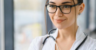 Hastanedeki beyaz önlüklü genç kadın portresi.