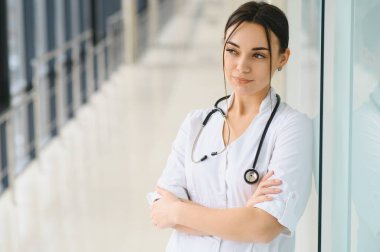 Hastanedeki beyaz önlüklü genç kadın portresi.