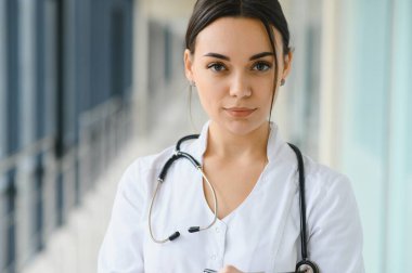 Mutlu genç bayan doktor üniforma, beyaz sağlık önlüğü, steteskop giyer. Güzel kadın doktor, terapist, hemşire portresi.