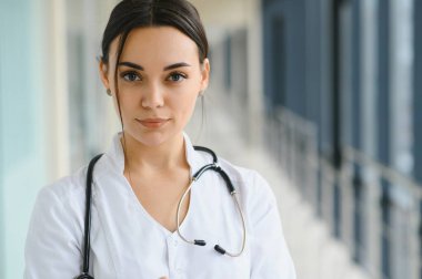 Hastane koridorunda duran genç bayan doktorun portresi. Beyaz kadın huzurevinde çalışıyor.