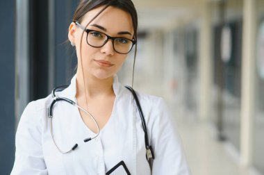 Hastanedeki beyaz önlüklü genç kadın portresi.