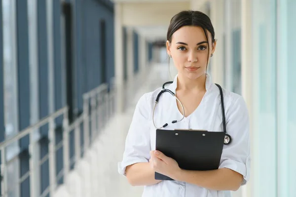 stock image Woman doctor standing with folder at hospital