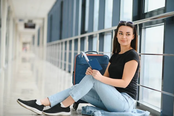 stock image happy woman waiting for flight at airport.