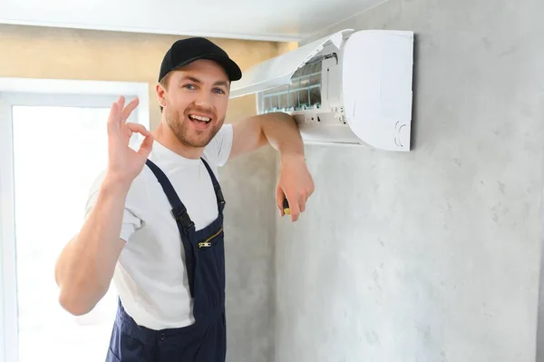 幸せの男性技術者がエアコンの修理 — ストック写真