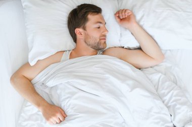 Evde yumuşak battaniyenin altında uyuyan yakışıklı adam..
