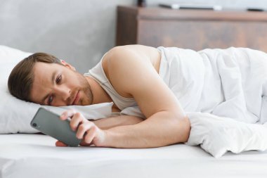 Young man in bed , trying to sleep. clipart