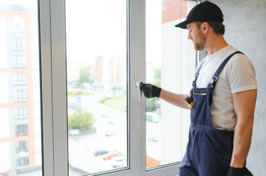 İnşaat işçisi eve pencere kuruyor.