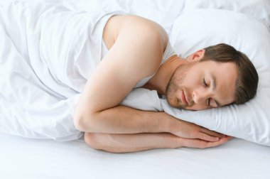 Evde yumuşak battaniyenin altında uyuyan yakışıklı adam..