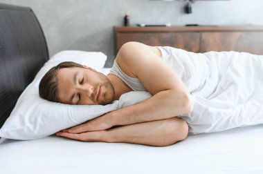 Evde yumuşak battaniyenin altında uyuyan yakışıklı adam..