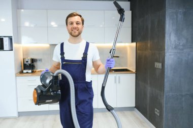 Adam düz elektrikli süpürge ile temizlik.