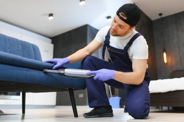 Profesyonel temizlikçi odayı süpürüyor, yakın plan..