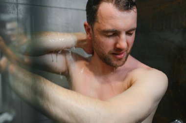 rahatlatıcı time.fresh duş concept.under iyi görünümlü adam su damlaları altında olduğunu.