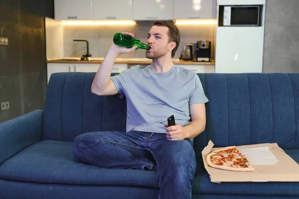 Szczęśliwy Młody Człowiek Pijący Piwo Jedzący Pizzę Podczas Oglądania Meczu — Zdjęcie stockowe