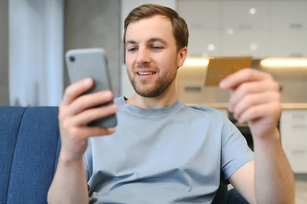 Szczęśliwy Biały Człowiek Kupuje Rzeczy Online Pomocą Smartfona Laptopa Karty — Zdjęcie stockowe