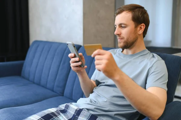 stock image Online payment,Man holding a credit card and using smart phone for online shopping.