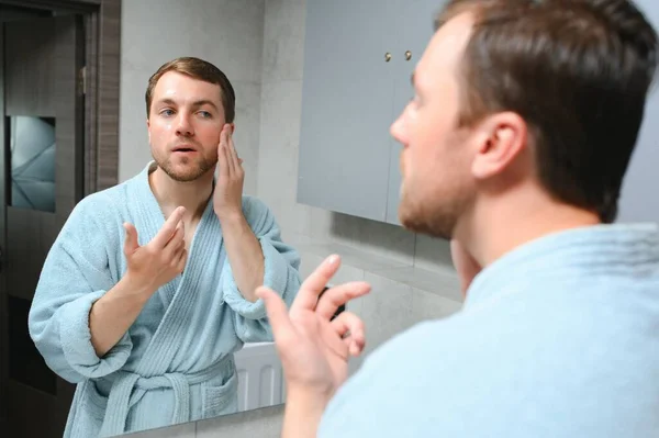 Handsome Man Looking Mirror Applying Moisturizing Cream Cheeks Bathroom Groomed — Stock Photo, Image