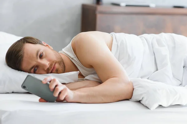 stock image Young man in bed , trying to sleep.