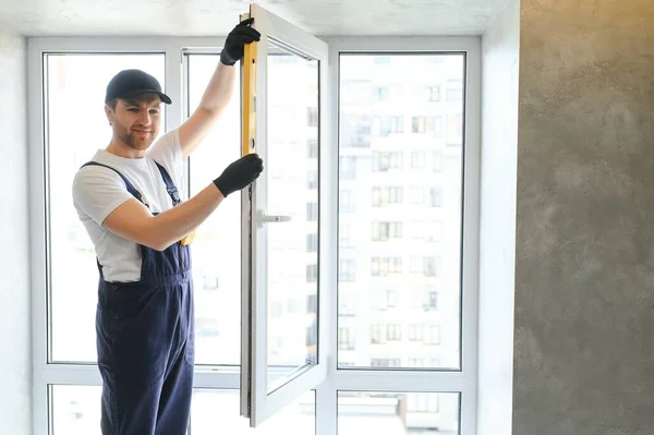 Robotnik Budowlany Naprawia Okna Plastikowe Pomieszczeniach Miejsce Tekst Projekt Banera — Zdjęcie stockowe