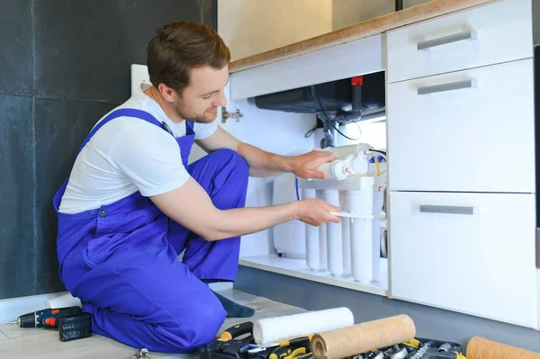 stock image plumber change the water filter.