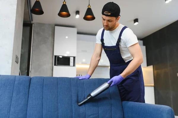 stock image Professional janitor vacuuming armchair in room, closeup.