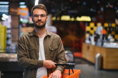 Yakışıklı adam bir süpermarkette alışveriş.