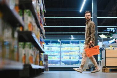 Yakışıklı adam bir süpermarkette alışveriş.