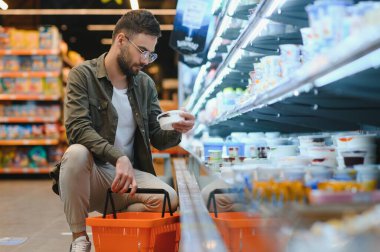 Yakışıklı adam bir süpermarkette alışveriş.