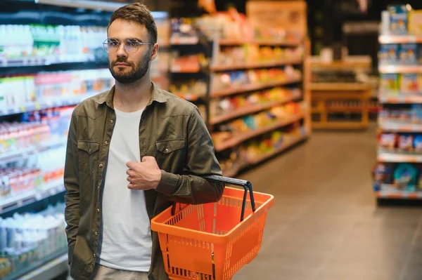 stock image Handsome young man choosing food in the supermarket