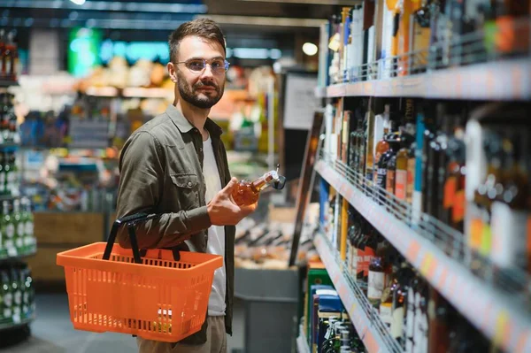 Bir Adam Süpermarketin Rafından Alkollü Içecekler Alır Alkol Almak Için — Stok fotoğraf