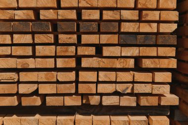 Ağaçtan toplanmış kereste yığını, yakın plan, arka plan. Tahta kereste fabrikası, marangozluk atölyesi. Tahta testeresi ve hava kurutma. Ahşap endüstrisi. Tahta tahtalar..