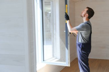 İşçi eve pencere kurup kontrol ediyor
