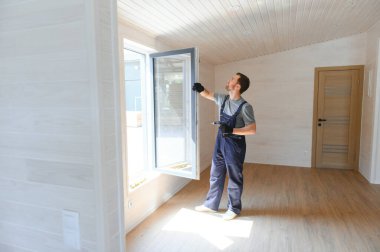 İşçi eve pencere kurup kontrol ediyor