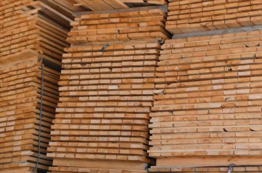 Ağaçtan toplanmış kereste yığını, yakın plan, arka plan. Tahta kereste fabrikası, marangozluk atölyesi. Tahta testeresi ve hava kurutma. Ahşap endüstrisi. Tahta tahtalar..