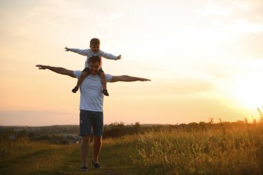 Babalar Günü. Baba ve oğul yazın dışarıda birlikte oynuyorlar. Mutlu aile, baba, oğul gün batımında