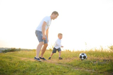 Babalar Günü. Baba ve oğul yazın dışarıda birlikte oynuyorlar. Mutlu aile, baba, oğul gün batımında