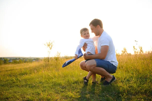 아드님의 아버지가 장난감 비행기와 노을에 아들을 — 스톡 사진