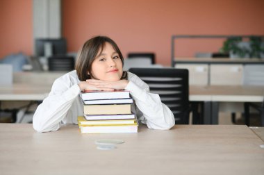 Eğitim ve okul konsepti - Öğrenci kız okulda okuyor ve kitap okuyor